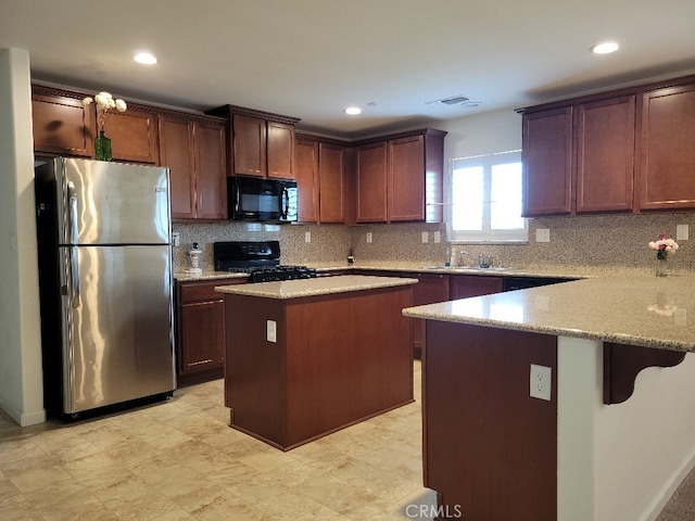 kitchen with black appliances, a kitchen island, sink, and backsplash