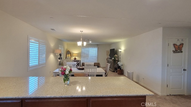 kitchen featuring carpet floors, a chandelier, and decorative light fixtures