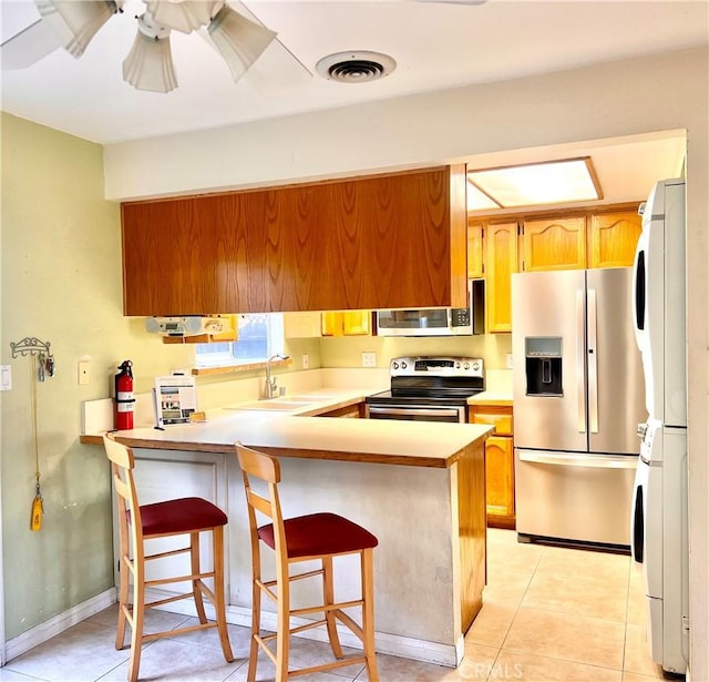 kitchen with sink, a breakfast bar area, stainless steel appliances, and kitchen peninsula