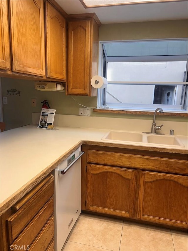 kitchen featuring dishwasher, sink, and light tile patterned floors