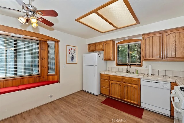 kitchen featuring ceiling fan, tile countertops, light hardwood / wood-style floors, sink, and white appliances