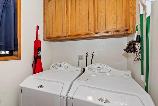 laundry area featuring separate washer and dryer and cabinets