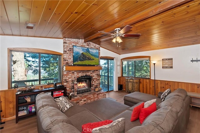 living room with hardwood / wood-style floors, wooden ceiling, ceiling fan, a brick fireplace, and lofted ceiling with beams