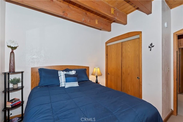 bedroom featuring a closet, beam ceiling, and wooden ceiling