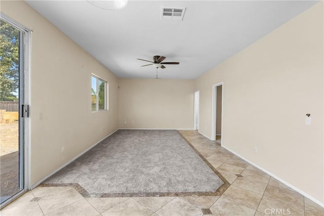 spare room with ceiling fan and light tile patterned floors