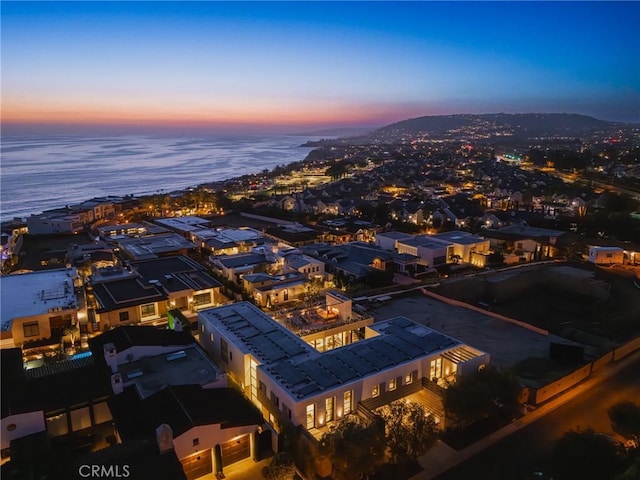 aerial view at dusk featuring a water view