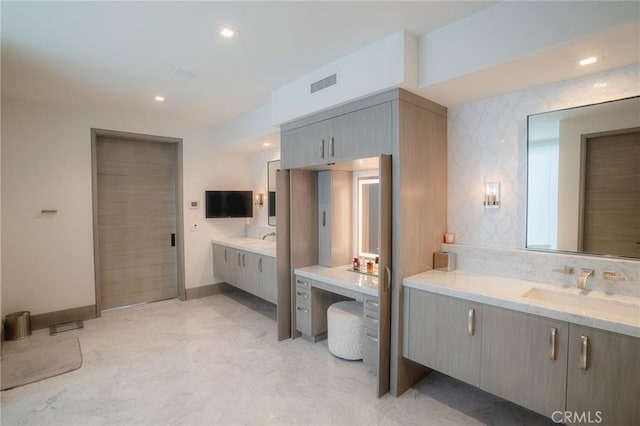 full bath featuring visible vents, two vanities, a sink, recessed lighting, and baseboards