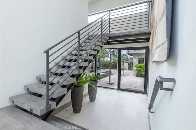 staircase featuring a high ceiling