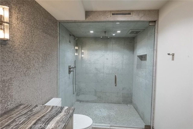 bathroom featuring visible vents, toilet, and a shower stall