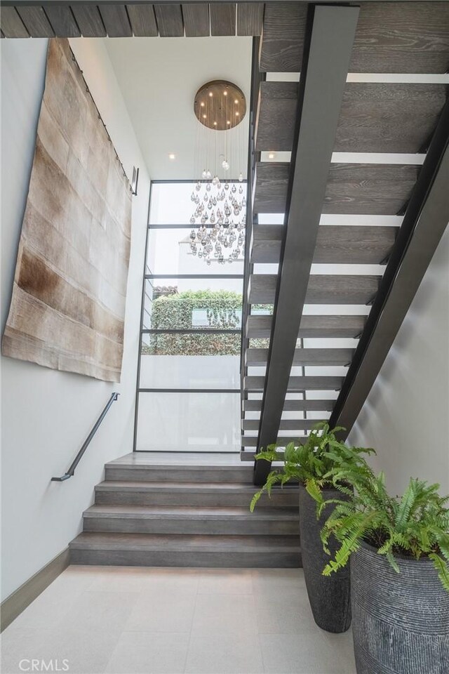 staircase featuring a notable chandelier