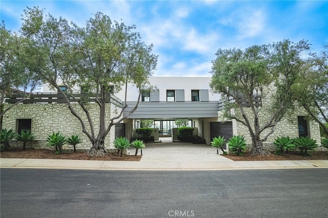 view of front of property featuring a carport, driveway, and a garage