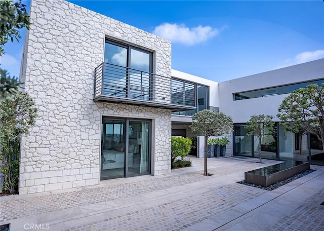 entrance to property featuring stucco siding and a balcony