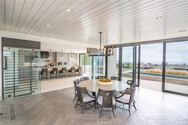 dining area with parquet flooring, a notable chandelier, and expansive windows