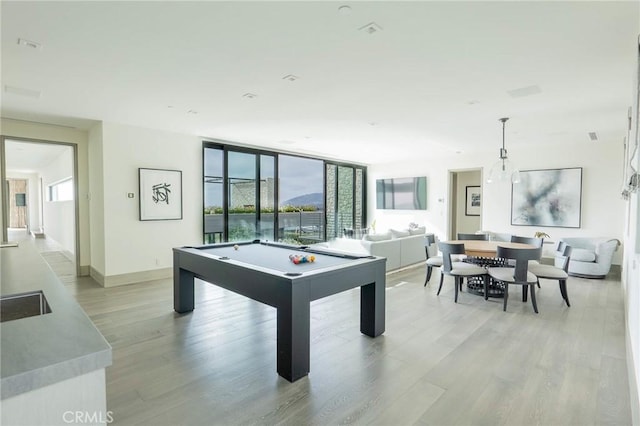 recreation room with billiards, baseboards, light wood-type flooring, and expansive windows