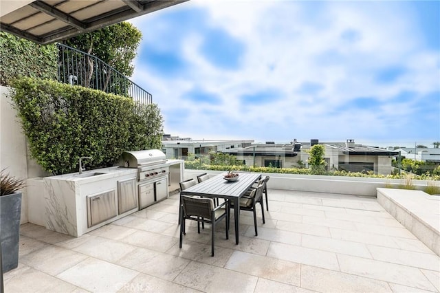 view of patio with sink, exterior kitchen, and a grill