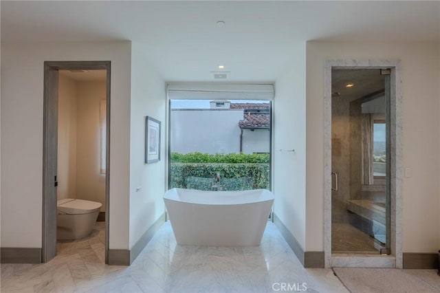 bathroom featuring toilet and separate shower and tub