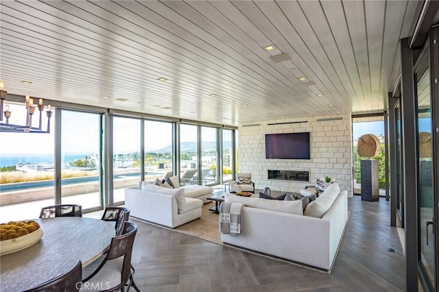 living room featuring expansive windows, wood ceiling, and a large fireplace