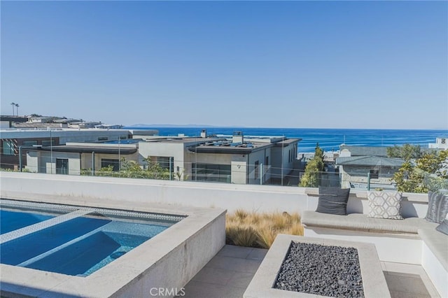 exterior space with a water view and an outdoor fire pit