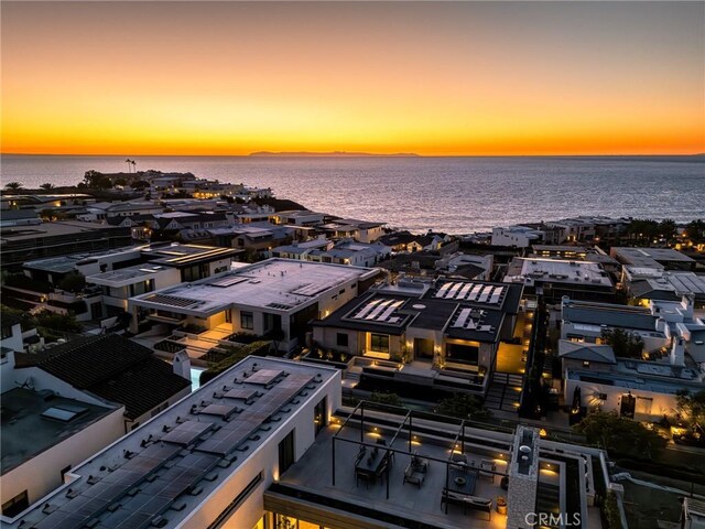 aerial view at dusk featuring a water view