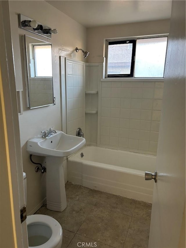 full bathroom with tiled shower / bath combo, toilet, a wealth of natural light, and sink