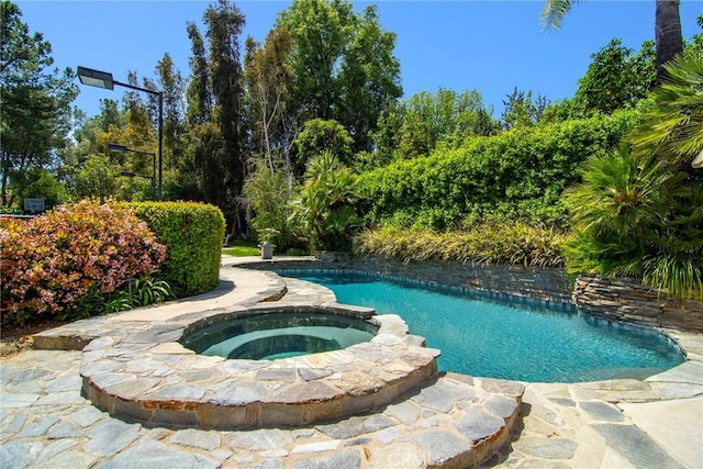 view of swimming pool with an in ground hot tub