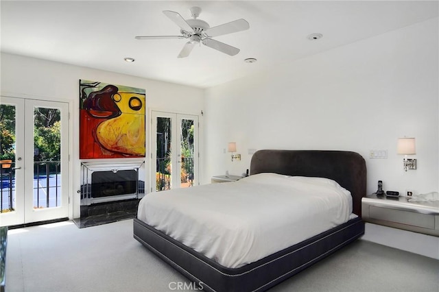 bedroom with ceiling fan, access to exterior, multiple windows, and french doors