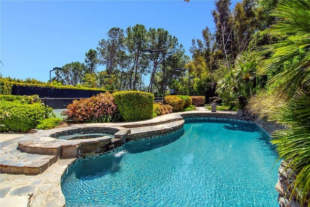 view of pool with an in ground hot tub