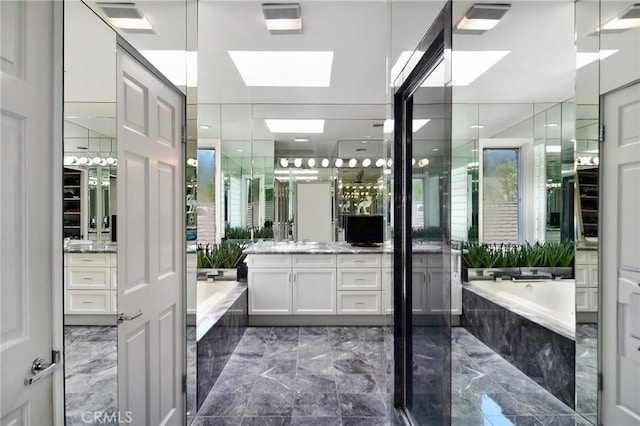 bathroom with vanity, a skylight, and independent shower and bath