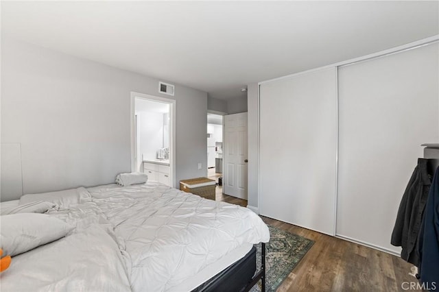 bedroom featuring dark hardwood / wood-style flooring, connected bathroom, and a closet