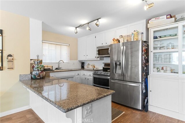 kitchen featuring white cabinetry, appliances with stainless steel finishes, kitchen peninsula, and sink