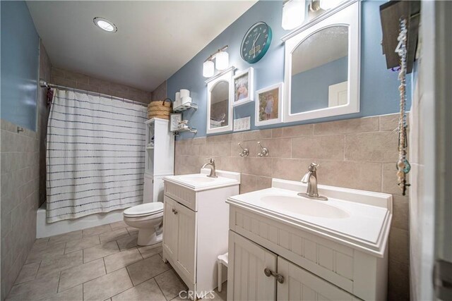 full bathroom featuring shower / bath combo, tile walls, tile patterned flooring, vanity, and toilet