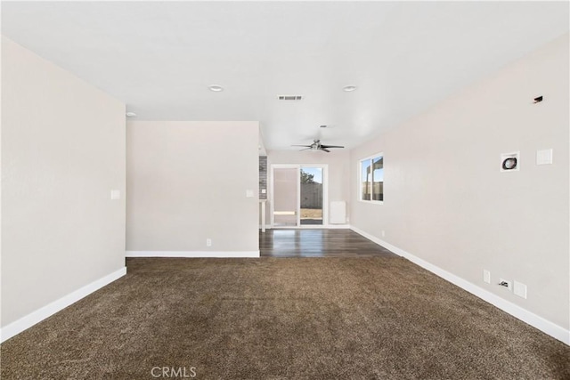 empty room with ceiling fan and dark carpet