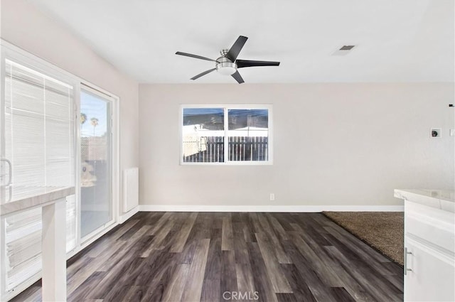 unfurnished room featuring ceiling fan and dark wood-type flooring