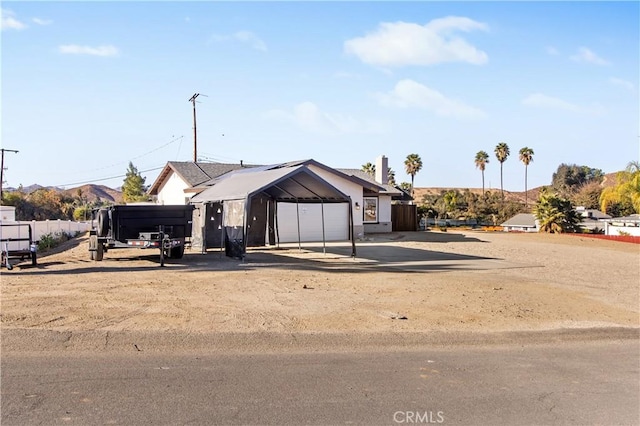 view of front of house with a garage, a carport, and a mountain view