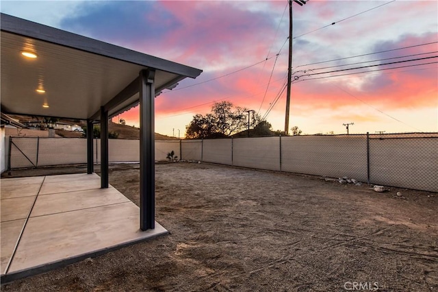 yard at dusk featuring a patio