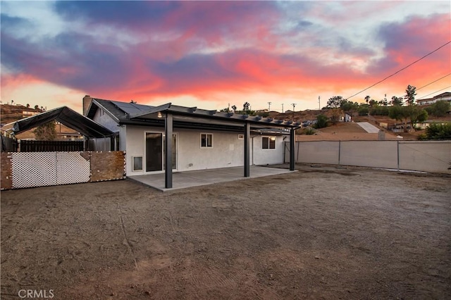 back house at dusk with a patio