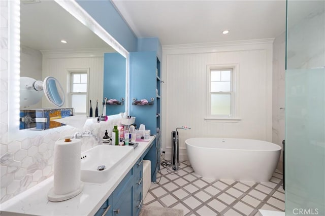 bathroom featuring a bathtub, ornamental molding, and vanity