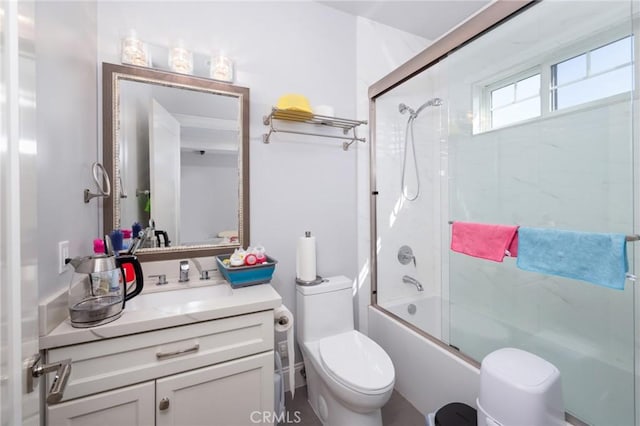 full bathroom featuring vanity, bath / shower combo with glass door, and toilet