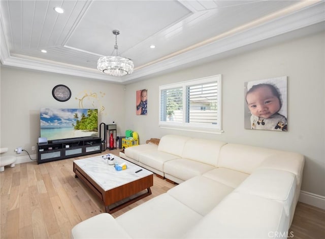 living room with wooden ceiling, crown molding, light hardwood / wood-style flooring, a tray ceiling, and a notable chandelier