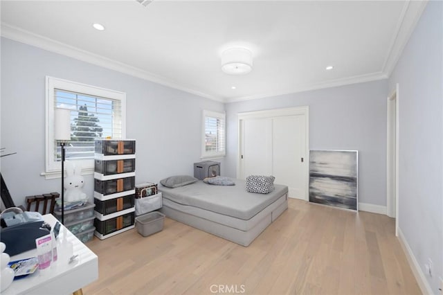 bedroom featuring light hardwood / wood-style flooring, multiple windows, and crown molding