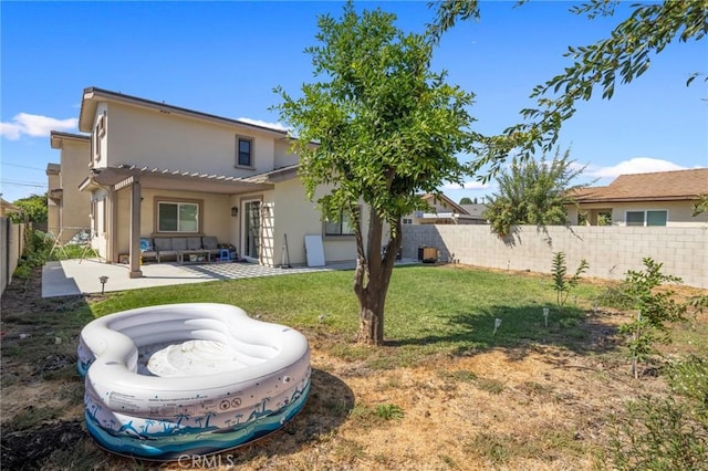 back of house featuring an outdoor living space, a yard, a patio, and a pergola