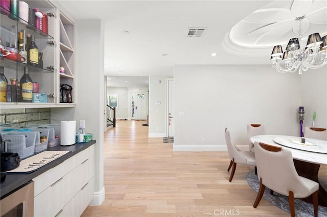 dining space featuring light hardwood / wood-style floors and wine cooler