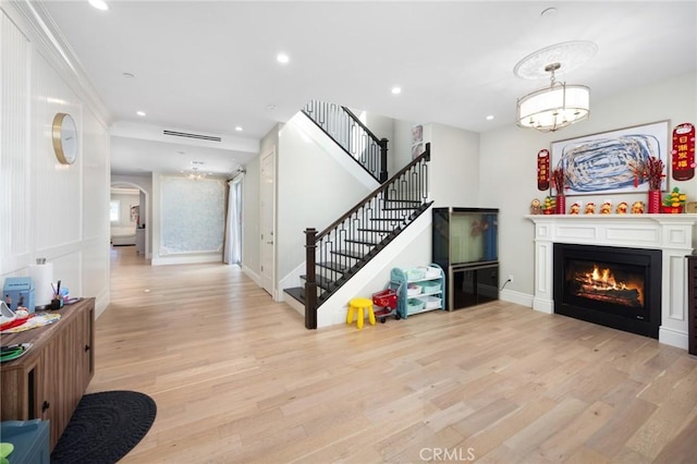 living room featuring ornamental molding and light wood-type flooring