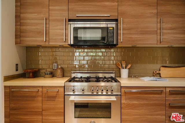 kitchen with decorative backsplash and stainless steel gas range oven