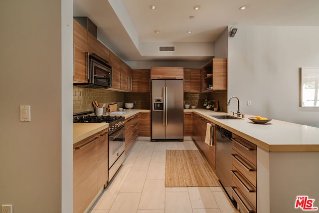 kitchen featuring decorative backsplash, sink, light tile patterned floors, and appliances with stainless steel finishes