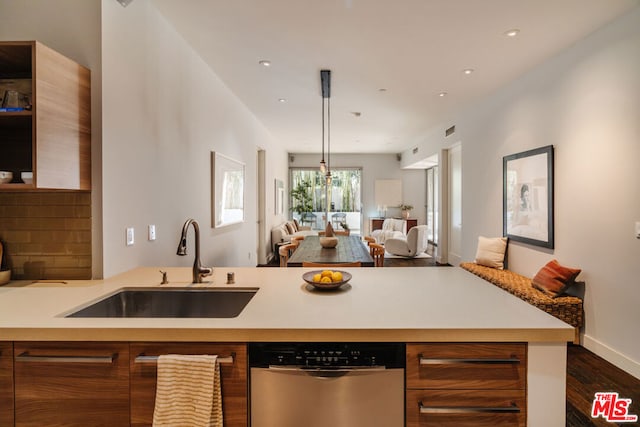 kitchen featuring dishwasher, dark wood-type flooring, decorative light fixtures, and sink