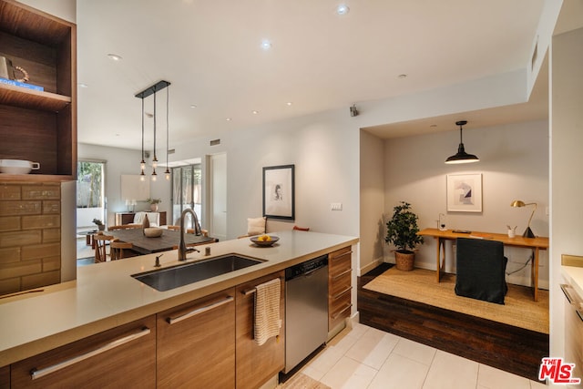 kitchen featuring pendant lighting, stainless steel dishwasher, and sink