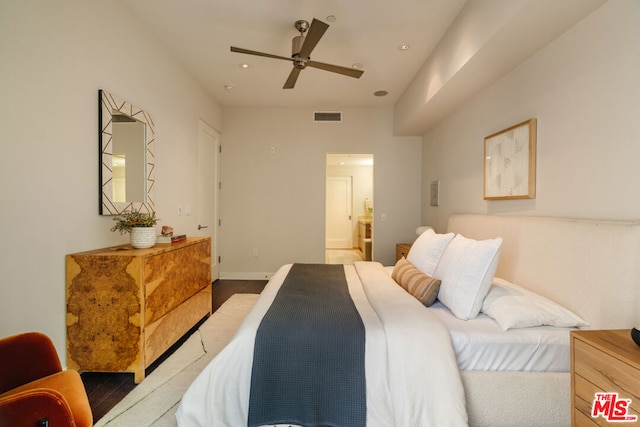 bedroom with hardwood / wood-style flooring, ceiling fan, and connected bathroom