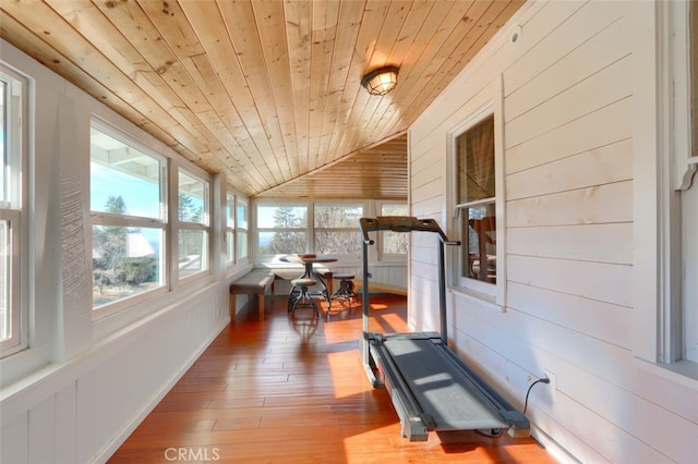 workout area with hardwood / wood-style floors, lofted ceiling, wood walls, and wood ceiling