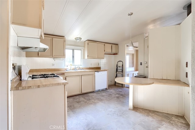 kitchen featuring stove, white dishwasher, hanging light fixtures, range hood, and cream cabinetry